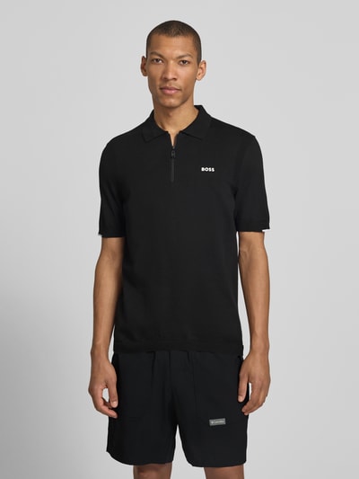 Męski model nosi Regular Fit Poloshirt aus reiner Baumwolle Modell 'KN_EVER-X' von BOSS Green, jednokolorowy, drobny splot, aplikacja z marką, kołnierzyk polo, dekolt w serek, krótki zamek błyskawiczny, krótki rękaw, prążkowane zakończenie, bawełna; całkowity widok z przodu.
