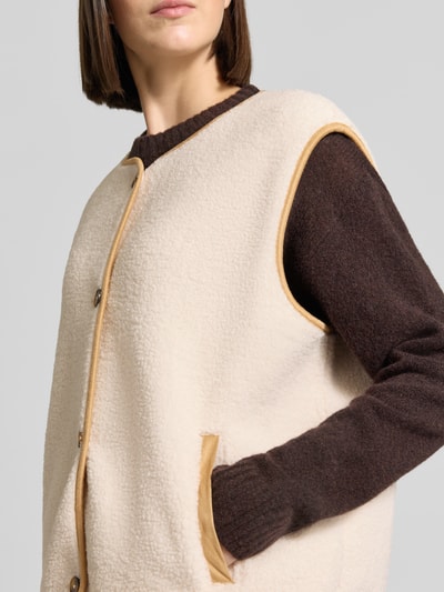 Vrouwenmodel draagt Relaxed Fit bodywarmer met doorlopende knoopsluiting van Christian Berg Woman, Teddybont, ronde hals, mouwloos, zij-steekzakken, detailopname bovenlichaam.