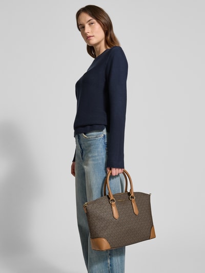 Kobieta modelka trzyma Handtasche mit Logo-Applikation Modell 'Murphy' von MICHAEL Michael Kors, wzór logo, brązowe i beżowe kolory, główna komora na zamek, odpinane uchwyty, szerokość w rozmiarze 1: 40 cm, długość: 26 cm, głębokość: 12 cm, długość paska: 120 cm, całkowity widok z przodu