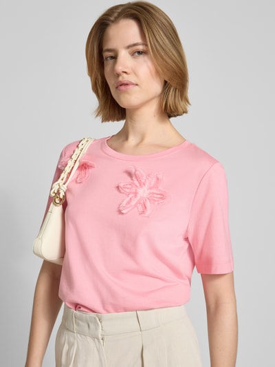 Frauenmodel trägt Regular Fit T-Shirt mit floralem Zierbesatz von monari, Damen T-Shirt aus Baumwoll-Modal-Mix in Rosa, Rundhalsausschnitt, Rückenlänge 59 cm bei Größe 36, Nahaufnahme Oberkörper.