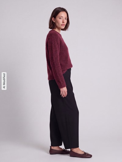 Frauenmodel trägt Regular Fit Pullover aus Woll-Mix Modell 'LULU' von Selected in Bordeaux und schwarze Hose, Damen Pullover, Ganzkörperansicht von vorne, KI-modifiziertes Bild.
