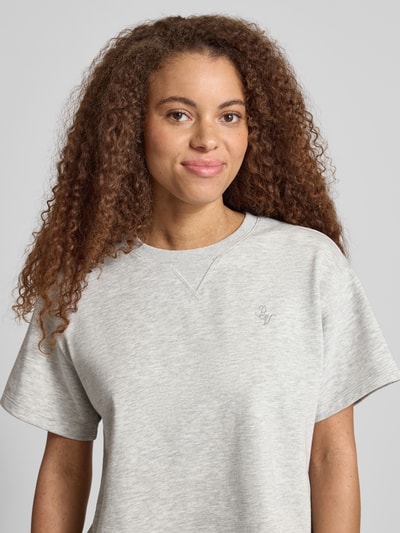 Frauenmodel trägt kurzärmeliges Sweatshirt mit Stickerei von REVIEW aus Baumwoll-Mix mit Viskose-Anteil, Relaxed-Fit, 1/2-Arm, Rückenlänge bei Größe S 53 cm, hellgraue Farbe, feine Struktur, Nahaufnahme Oberkörper.