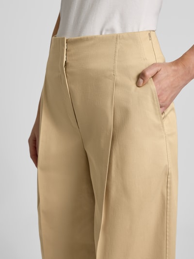 Frauenmodel trägt Straight Leg Bundfaltenhose aus Baumwoll-Mix Modell 'TULOTTA' von BOSS, Optik: Unifarben, Passform: Wide Leg, High-Waist, Label-Stitching-Applikation, Bügelfalten, seitliche Eingrifftaschen, Material: Baumwoll-Mix, Nahaufnahme Oberkörper.