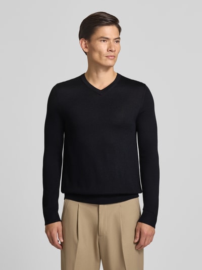 Männermodel trägt Strickpullover aus Woll-Mix mit V-Ausschnitt von Christian Berg Men in Schwarz, Regular Fit, Ganzkörperansicht von vorne.