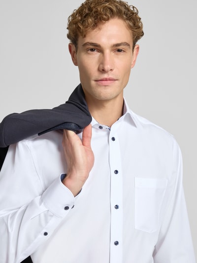Männermodel trägt Comfort Fit Businesshemd aus reiner katoen van OLYMP, wit met donkere knopen, Nahaufnahme Oberkörper, Heren zakelijk overhemd van OLYMP Luxor.