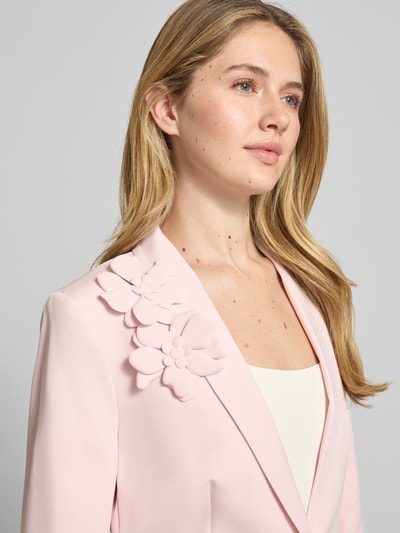 Frauenmodel trägt Regular Fit Blazer mit floralen Applikationen von Christian Berg Woman Selection in zartem Rosa, Reverskragen, Elastischer-Material-Mix; Nahaufnahme Oberkörper.