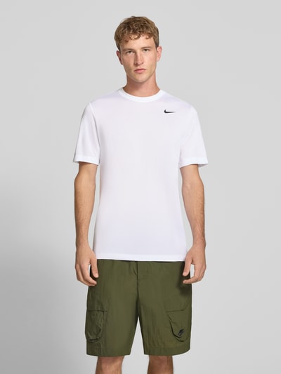 Männermodel trägt T-Shirt mit Logo-Print und Rundhalsausschnitt von NIKE TRAINING, weiß, gerader Schnitt, Regular Fit, Ganzkörperansicht von vorne.