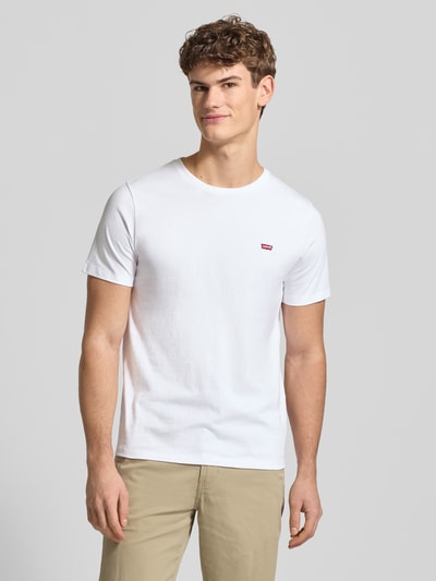 Männermodel trägt T-Shirt mit Label-Stitching von Levi's®, weiße Baumwolle, Regular-Fit, Rundhalsausschnitt, Ganzkörperansicht von vorne.