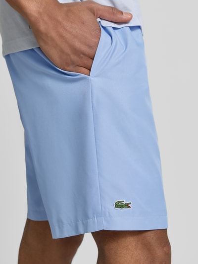 Männermodel trägt Relaxed Fit Sport-Shorts mit Logo-Stitching von Lacoste, Optik: Unifarben, seitliche Eingrifftaschen, Nahaufnahme Oberkörper