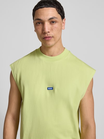 Männermodel trägt Relaxed Fit Tank Top aus reiner Baumwolle Modell 'NAVERTZ' von HUGO, unifarben, Label Patch, Rundhals, Nahaufnahme Oberkörper.