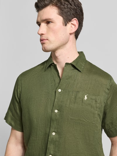 Männermodel draagt Regular Fit vrijetijdsoverhemd uit puur linnen van Polo Ralph Lauren, look: effen kleuren, gestikt logo, borstzak, korte mouw, gevlamd garen, materiaal: linnen, nahaufnahme bovenlichaam