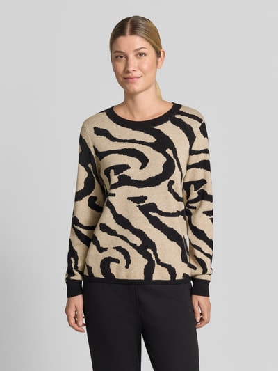 Frauenmodel trägt Strickpullover aus Viskose-Mix Modell 'TIF' von VILA im Allover-Look, Beige mit schwarzen Muster, Regular Fit, Rundhalsausschnitt, Ganzkörperansicht von vorne.