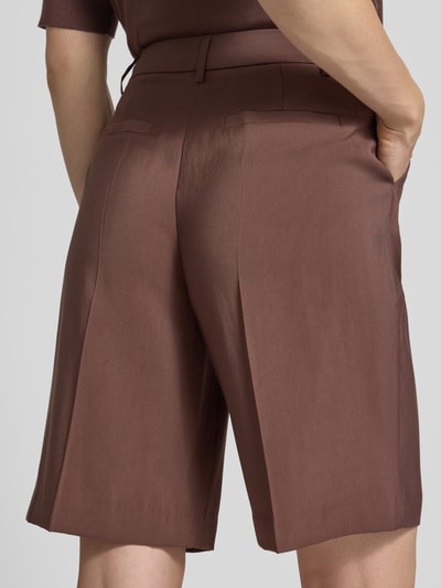 Frauenmodel trägt Bermudas aus Viskose-Mix Modell 'ESSIE' von B.Young, Regular-Fit, Bügelfalten, glatte Textur, Rückansicht Ganzkörperansicht. Bundweite 37 cm, Innenbeinlänge 28 cm bei Größe 36.