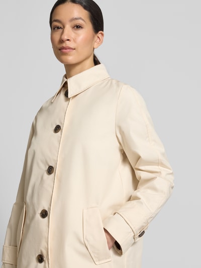 Frauenmodel trägt Regular Fit Trenchcoat aus Baumwoll-Mix von s.Oliver RED LABEL in Beige, einreihige Knopfleiste, Twill-Struktur, Nahaufnahme Oberkörper.