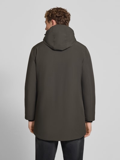 Männermodel trägt Regular Fit Parka mit Logo-Print von Lindbergh aus elastyczna mieszanka materiałów, kolor ciemnozielony, Ganzkörperansicht Rückansicht. Kontekst: parka, krój regular fit, nadruk z logo, kaptur z tunelem, napoleońska kieszeń, zamek błyskawiczny, długość tyłu w rozmiarze M: 90 cm, szerokość ramion w rozmiarze M: 50 cm, szerokość w klatce piersiowej w rozmiarze M: 58 cm, długość rękawów w rozmiarze M: 65 cm.