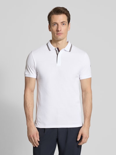 Männermodel trägt Slim Fit Poloshirt aus Baumwolle von Colmar Originals in Weiß mit Polokragen, Label-Details, Ganzkörperansicht von vorne. Rückenlänge bei Größe M: 66 cm.