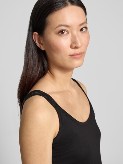 Frauenmodel trägt Tanktop mit Rundhalsausschnitt und Label-Detail von monari aus Baumwoll-Modal-Mix im Regular-Fit, Nahaufnahme Oberkörper. Rückenlänge bei Größe 36: 47 cm.