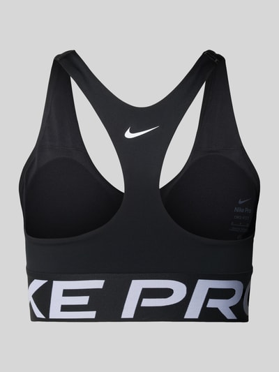 Produktfoto, Racerback-Bustier mit Cut Out und Label-Details von NIKE TRAINING, schwarzer Material-Mix mit Stretch-Anteil, körpernahe Passform