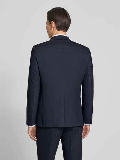 Männermodel trägt Slim Fit Anzug mit Schurwoll-Anteil Modell 'HUGE' von BOSS in Dunkelblau mit feinem Allover-Muster, Ganzkörperansicht Rückansicht.
