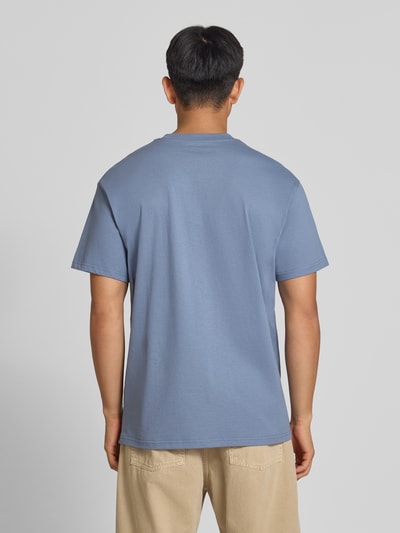 Męski model trägt Regular Fit T-Shirt aus reiner bawełna Model 'American Script' von Carhartt Work In Progress, detal z logo, Długość tyłu w rozmiarze M: 75 cm, kolor niebieski, gładka faktura, Ganzkörperansicht Rückansicht.