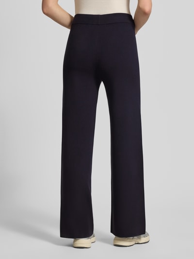Frauenmodel trägt Lounge-Hose mit Längsnähten und elastischem Bund von comma, dunkelblau, Relaxed Fit, Ganzkörperansicht Rückansicht.