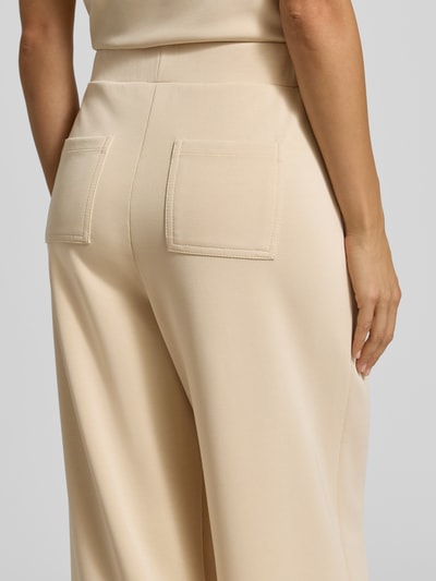 Frauenmodel trägt Wide Leg Sweatpants aus Modal-Mix von Rich & Royal in Beige mit Gesäßtaschen, Detailaufnahme Rückansicht.