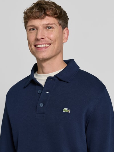 Männermodel trägt Regular Fit Sweatshirt aus reiner Baumwolle von Lacoste in Dunkelblau, dezente Struktur, Nahaufnahme Oberkörper. Herren Sweatshirt von Lacoste.