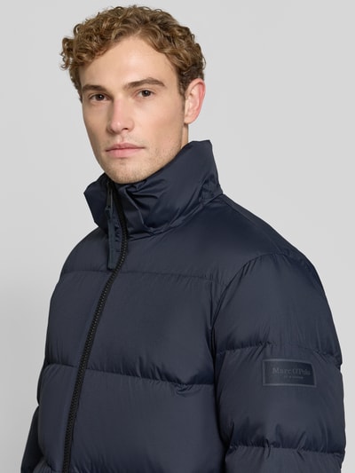 Männermodel trägt Regular Fit Daunenjacke mit Kapuzenkragen von Marc O'Polo, Look: effen, Materiaalverwerking: geweven stof, labelpatch, waterafstotend, steekzakken, lange mouwen, tweewegritssluiting, Nahaufnahme Oberkörper.