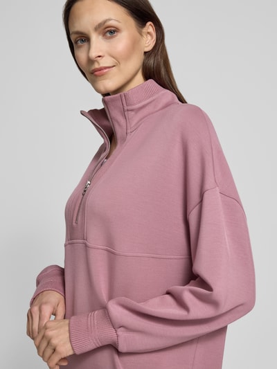Frauenmodel trägt Sweatshirt mit Troyer-Kragen Modell 'molly' von VARLEY aus Viskose-Mix mit Stretch-Anteil, Relaxed-Fit, gerippte Ärmelabschlüsse, Nahaufnahme Oberkörper.
