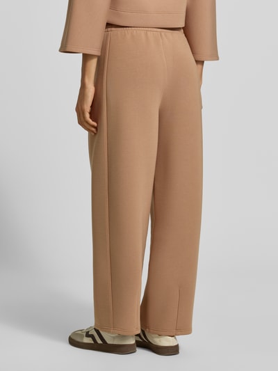 Männermodel trägt Wide Leg Sweathose aus Modal-Mix Modell 'GETTO' von Weekend Max Mara, beżowy kolor, lekko teksturowany materiał, Ganzkörperansicht Rückansicht.