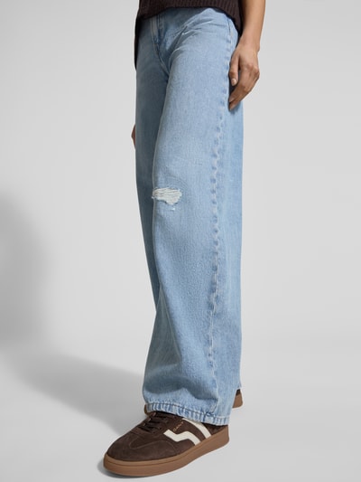 Frauenmodel trägt Relaxed Fit Jeans im Used-Look Modell 'MEDLEY' von Drykorn aus reiner Baumwolle, hellblaue Waschung, Nahaufnahme Unterkörper.