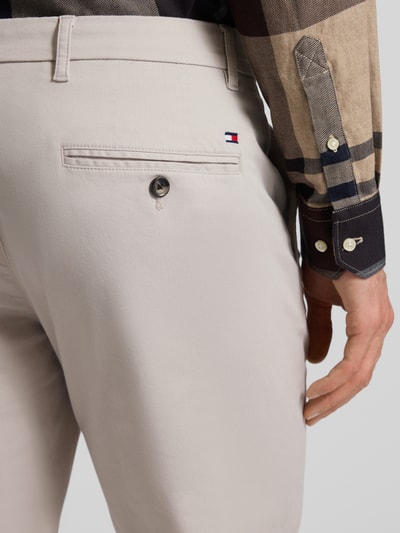 Männermodel trägt Regular Fit Chino aus Baumwoll-Mix Modell 'DENTON' von Tommy Hilfiger, helle Farbe, Detailaufnahme Gesäßtasche. Optik:Allover-Muster, Passform: Regular-Fit, Gürtelschlaufen, Knopf und verdeckter Reißverschluss, seitliche Eingrifftaschen, Gesäßtaschen, Material: Baumwoll-Mix.