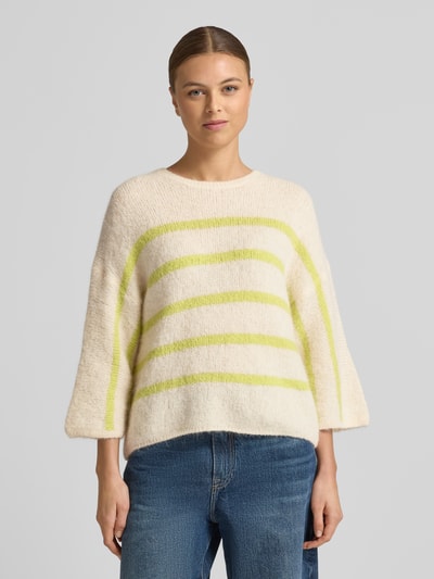 Frauenmodel trägt Strickpullover mit 3/4-Ärmel von Rich & Royal, Alpaka-Mix, locker geschnitten, creme mit gelben Streifen, Nahaufnahme Oberkörper.