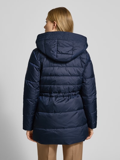 Vrouwenmodel draagt Daunenmantel mit Kapuze van Lauren Ralph Lauren in donkerblauw, getailleerde snit, capuchon, rugaanzicht.