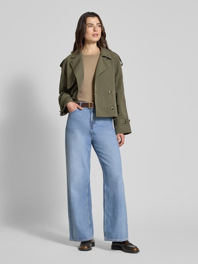 Frauenmodel trägt Boxy Fit Trenchcoat mit doppelreihiger Knopfleiste Modell 'CHLOE' von Vero Moda, khaki, lange Raglanärmel, seitliche Eingrifftaschen, Umlegekragen, schlichter Stoff, Ganzkörperansicht von vorne.