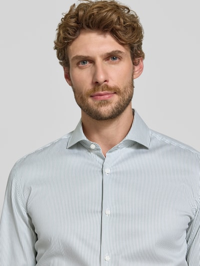Männermodel trägt Slim Fit Businesshemd aus Baumwoll-Mix Modell 'HANK' von BOSS, feine Streifen in Hellgrau und Weiß, Nahaufnahme Oberkörper, Herren Businesshemd von BOSS