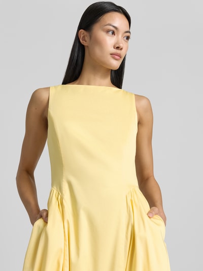 Frauenmodel trägt Midikleid mit Rundhalsausschnitt Modell 'NICOLE' von MANGO in Hellgelb, Baumwoll-Elasthan-Mix, Nahaufnahme Oberkörper.