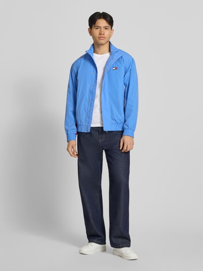 Männermodel trägt Regular Fit Blouson mit Logo-Stitching von Tommy Hilfiger in Blau, Optik: Unifarben, Satin, Ganzkörperansicht von vorne.