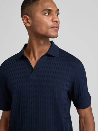 Męski model nosi Poloshirt mit gerippten Abschlüssen Modell 'Cleison' von JOOP! Collection, granatowy, bawełna, regular fit, zbliżenie na górną część ciała.