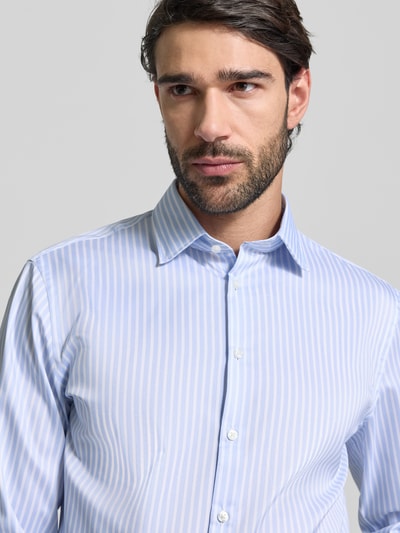Männermodel trägt Slim Fit Business-Hemd mit Kentkragen von Jake*s, Elastischer-Material-Mix, feine blaue Streifen, Nahaufnahme Oberkörper.