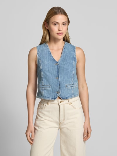 Frauenmodel trägt Regular Fit Weste in Denim-Optik von Mustang aus Baumwoll-Mix mit Paspeltaschen, V-Ausschnitt, Knopfleiste, Nahaufnahme Oberkörper.