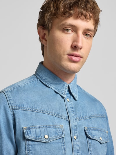Männermodel trägt Regular Fit Jeanshemd aus reiner Baumwolle Modell 'BROOKS' von Pepe Jeans in Denim-Optik, Nahaufnahme Oberkörper.