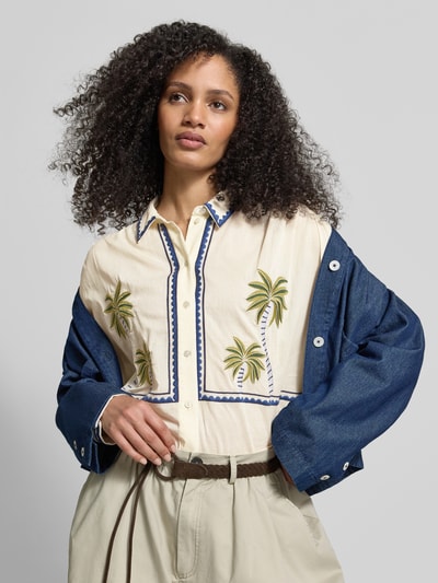 Kobiece model prezentuje Regular Fit Hemdbluse mit floralem Stitching od Jake*s Casual, beż z zielonym haftem, kołnierzyk koszulowy, listwa guzikowa, zakończenia rękawów obszyte, długość tyłu 61 cm, długość rękawa 57 cm, widok na górną część ciała z przodu.
