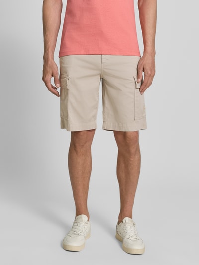 Männermodel trägt Relaxed Fit Cargoshorts aus Baumwoll-Mix Modell 'SISLA' von BOSS Orange, unifarben, mit Cargotaschen und Label Patch, Ganzkörperansicht von vorne.
