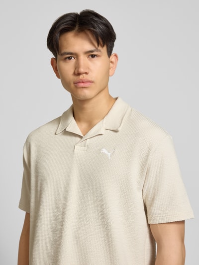 Männermodel trägt Regular Fit T-Shirt mit Logo-Stitching von PUMA PERFORMANCE im Strukturmuster, in Beige, Nahaufnahme Oberkörper.