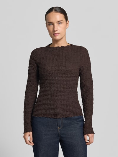 Frauenmodel trägt Regular Fit Langarmshirt aus Baumwoll-Mix Modell 'ZIA' von VERO MODA in Dunkelbraun mit strukturierter Oberfläche, Ganzkörperansicht von vorne, Damen Langarmshirt.