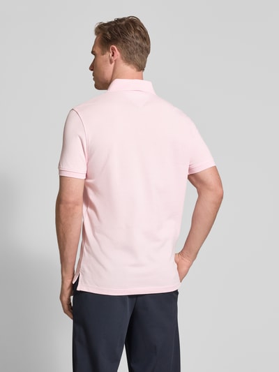 Męski model nosi Regular Fit Poloshirt aus Baumwoll-Mix od Tommy Hilfiger, efekt: jednolity kolor, krótki rękaw, wyhaftowane logo, kołnierzyk polo, zapięcie na 2 guziki, wykończenie: z rozcięciem, wykończenie materiału: pika, mieszanka bawełny, całkowity widok z tyłu.