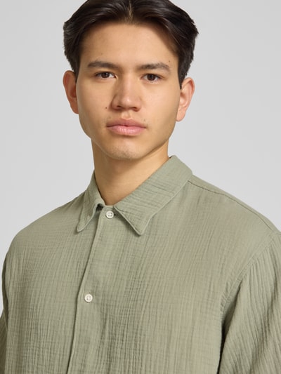 Männermodel trägt Regular Fit Freizeithemd mit Kentkragen von Jack & JonesR in Olivgrün, reine Baumwolle, Knopfleiste, Nahaufnahme Oberkörper.