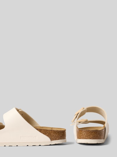 Productfoto, Slipper met logodetail Model 'Arizona' van Birkenstock, afgeronde pasvorm, open hiel, licht geprofileerde zool, hakhoogte maat 40: 3 cm, dames instappers, beige met bruine zool, glad oppervlak en subtiele structuur.