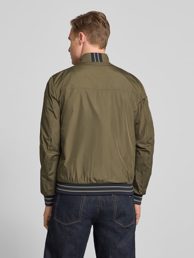 Männermodel trägt Blouson mit Stehkragen und Reißverschluss von Geox in Olivgrün, Regular-Fit, mit Eingrifftaschen, Rückenlänge 68 cm, Schulterbreite 46 cm, Brustweite 56 cm, Ärmellänge 68 cm, Ganzkörperansicht Rückansicht.
